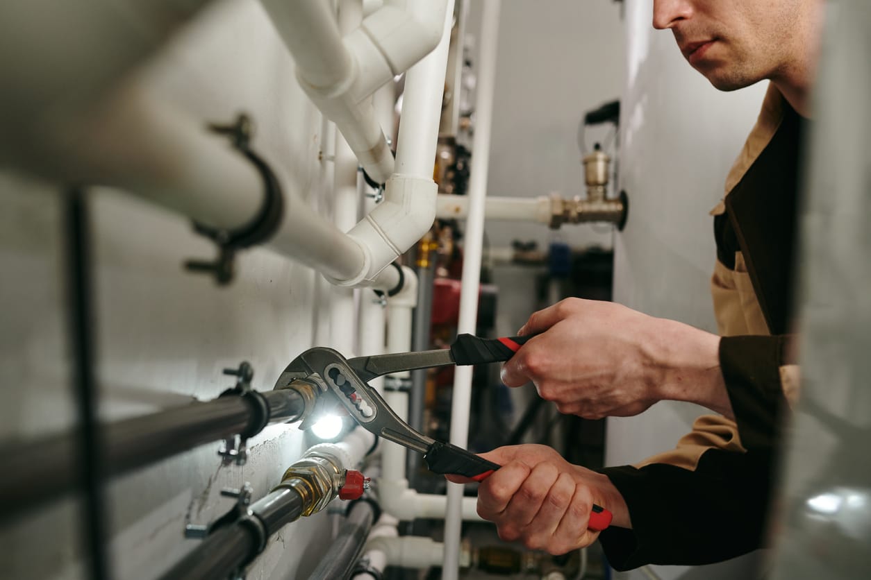 Plumbers maintaining commercial plumbing pipes in Immokalee