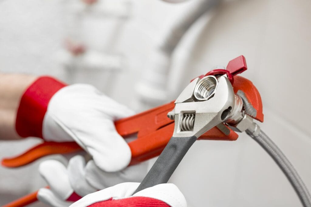 Plumber holding pipe wrenches for an emergency repair in Immokalee
