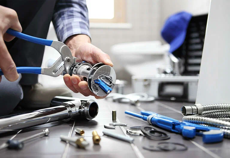 Technician repairing a plumbing fixture with professional tools in Immokalee