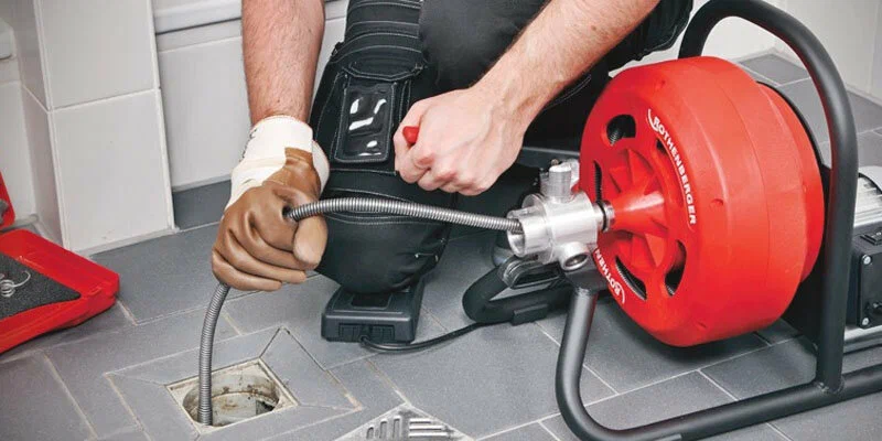 Plumber using a drain-cleaning machine in Immokalee