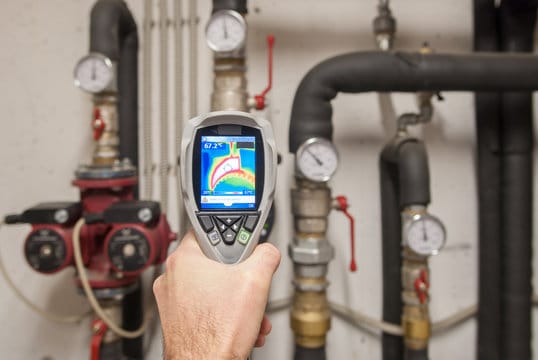 Plumber using a thermal imaging camera to inspect pipes in Immokalee