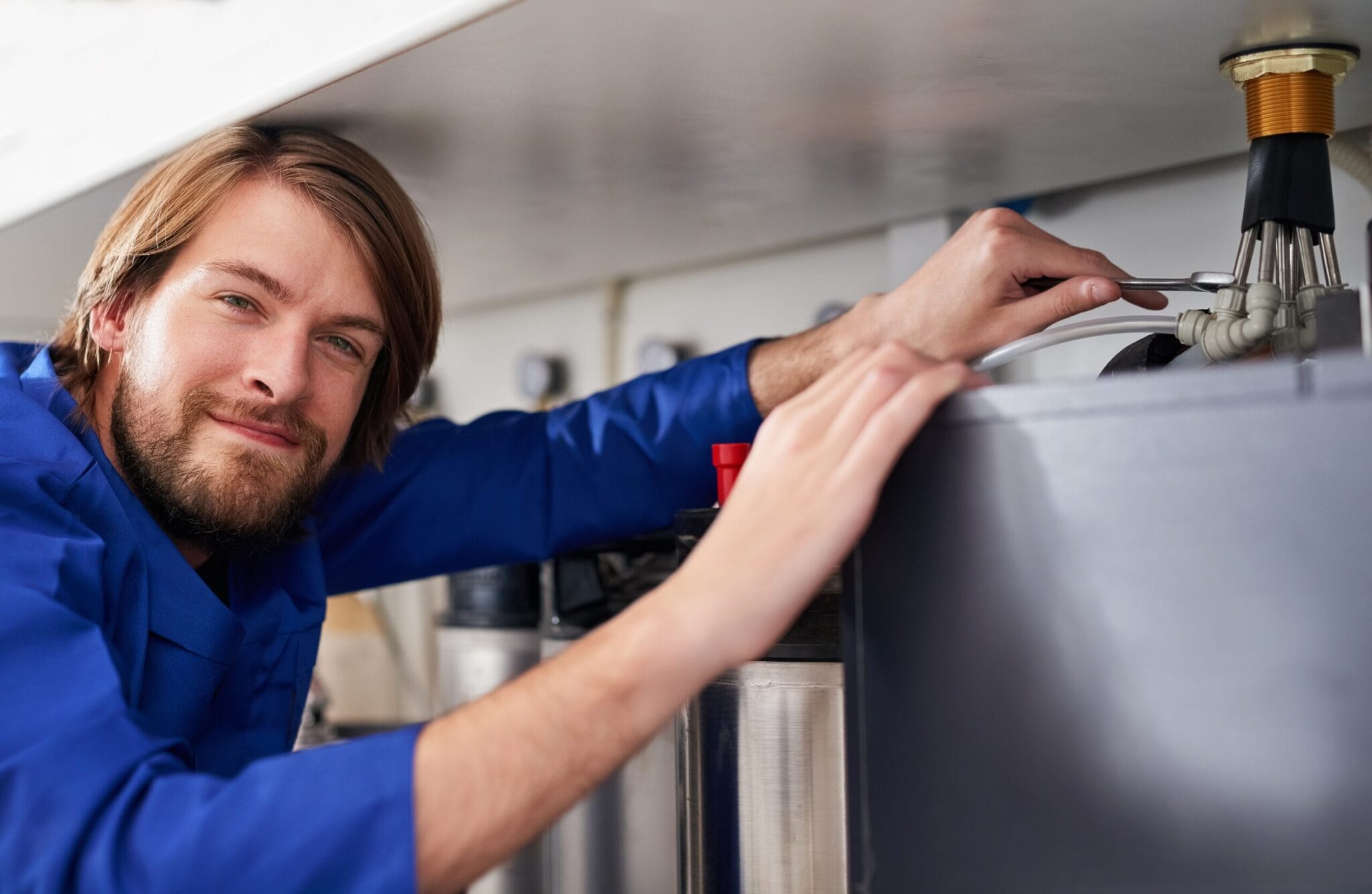 Technician servicing a residential water heater tank in Immokalee