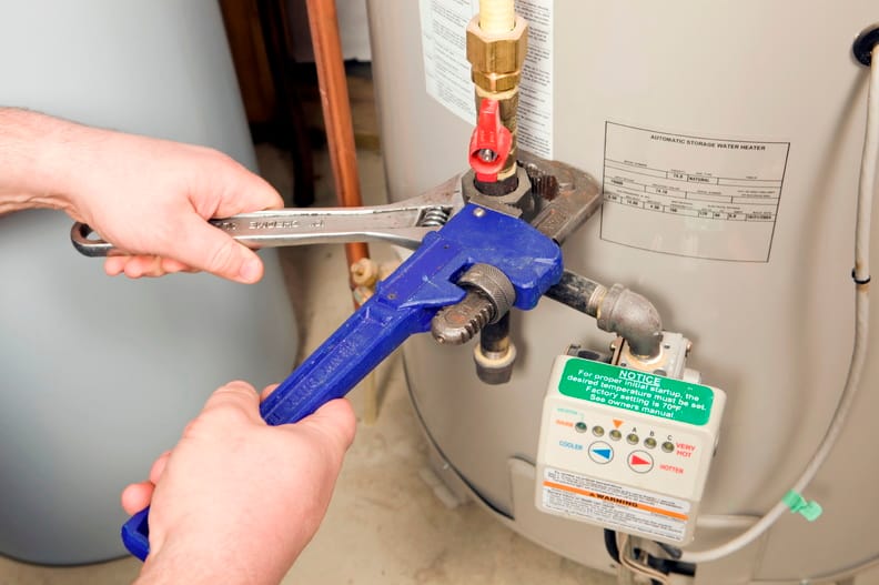 Plumber repairing a water heater valve in Immokalee